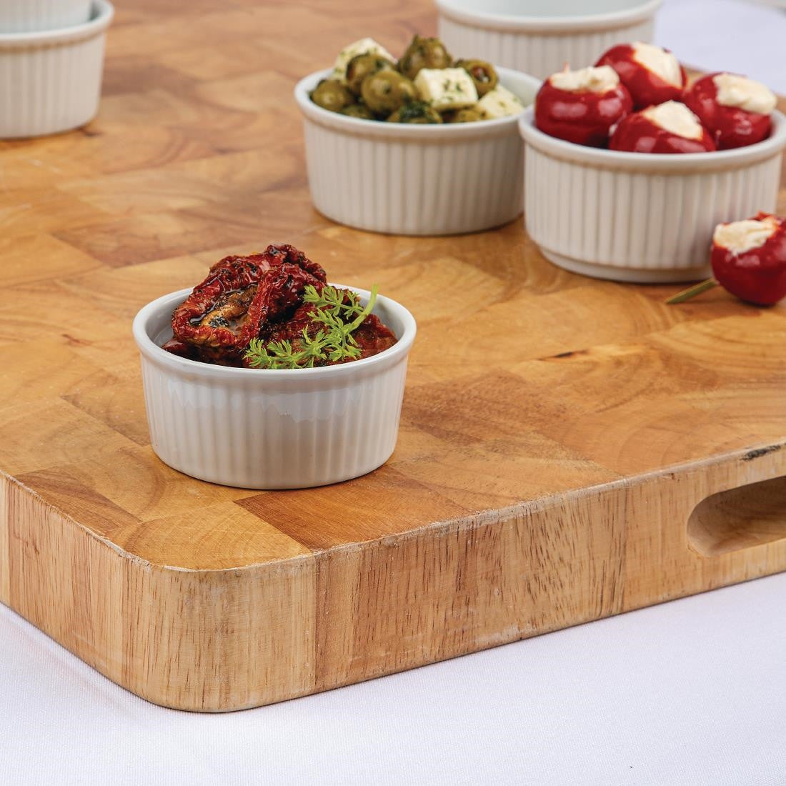 Olympia Whiteware Ramekins 80mm in a table with content together with other ramekins.