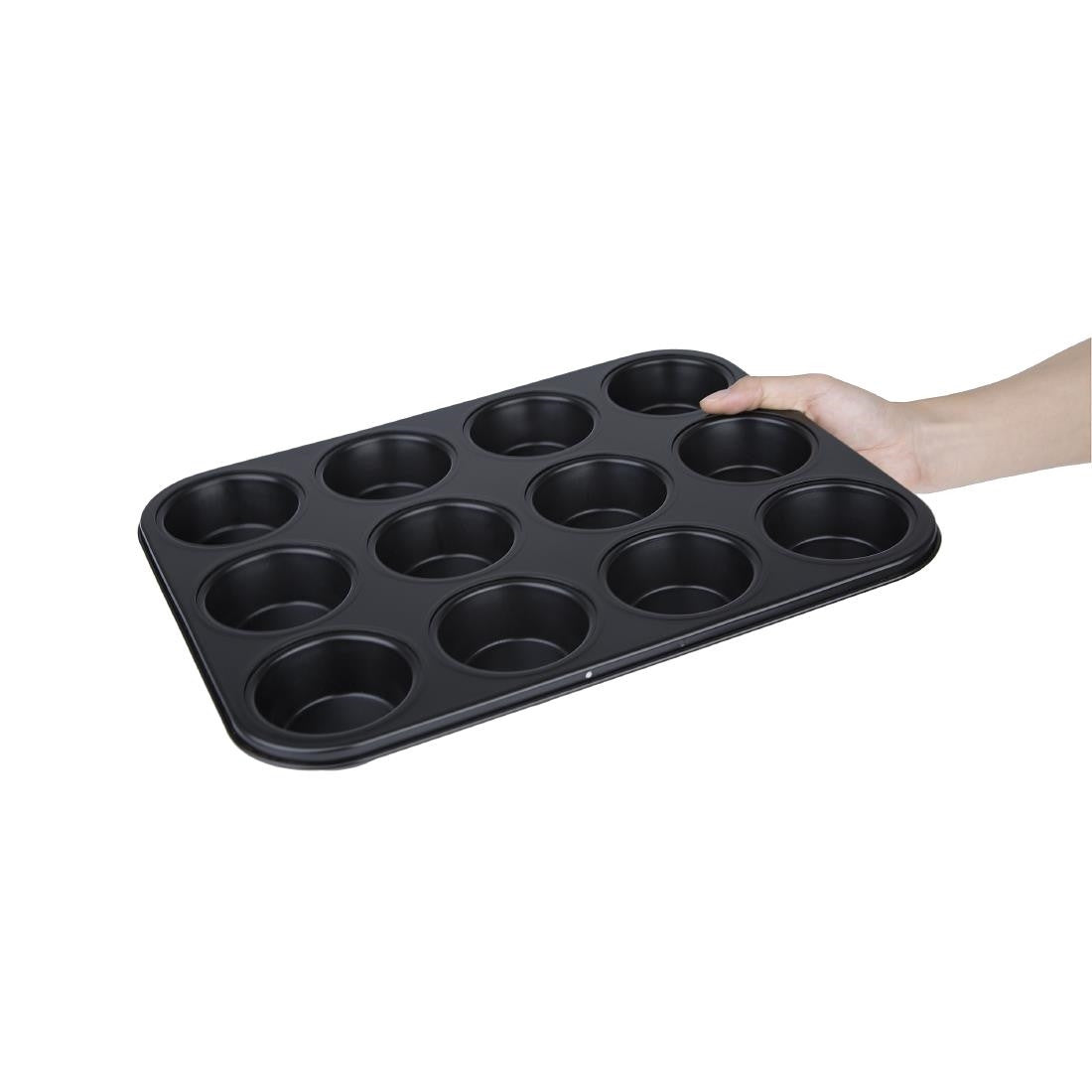 Full shot of a hand holding a Vogue Non Stick Muffin tray 12 cup.