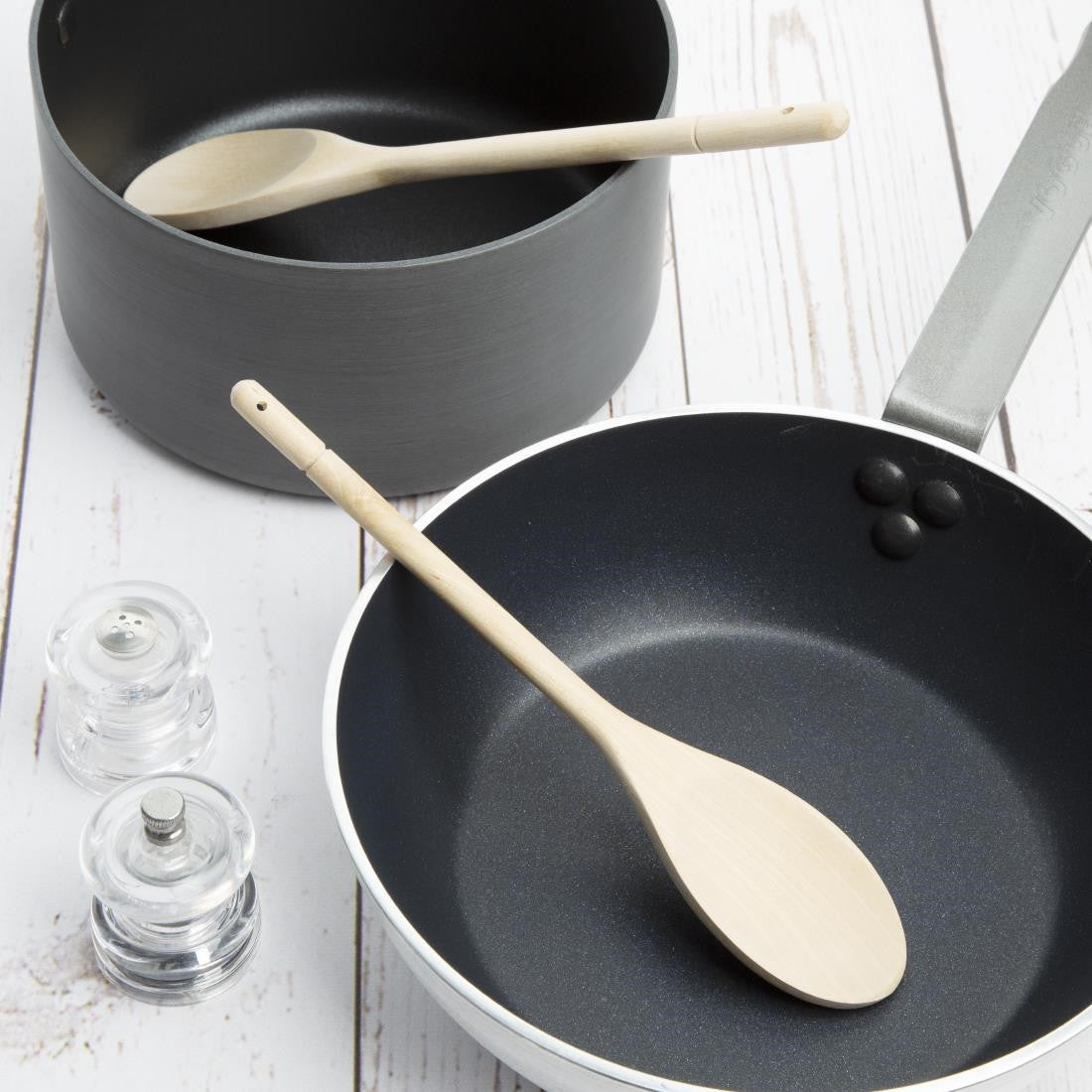 Vogue Wooden Spoon 10" with cooking pans on table.