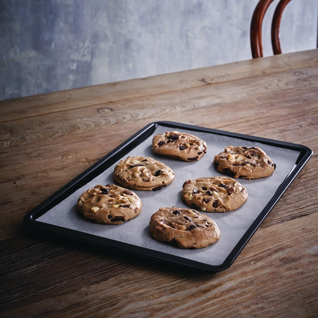Vogue Non-Stick Carbon Steel Baking Tray 370 x 257mm with baked cookies on table.