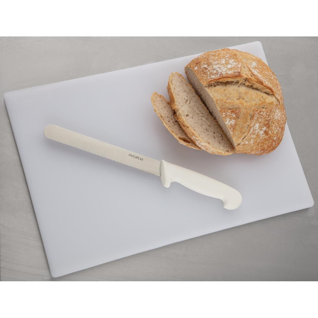 Hygiplas Low Density White Chopping Board Standard on table with bread and knife.