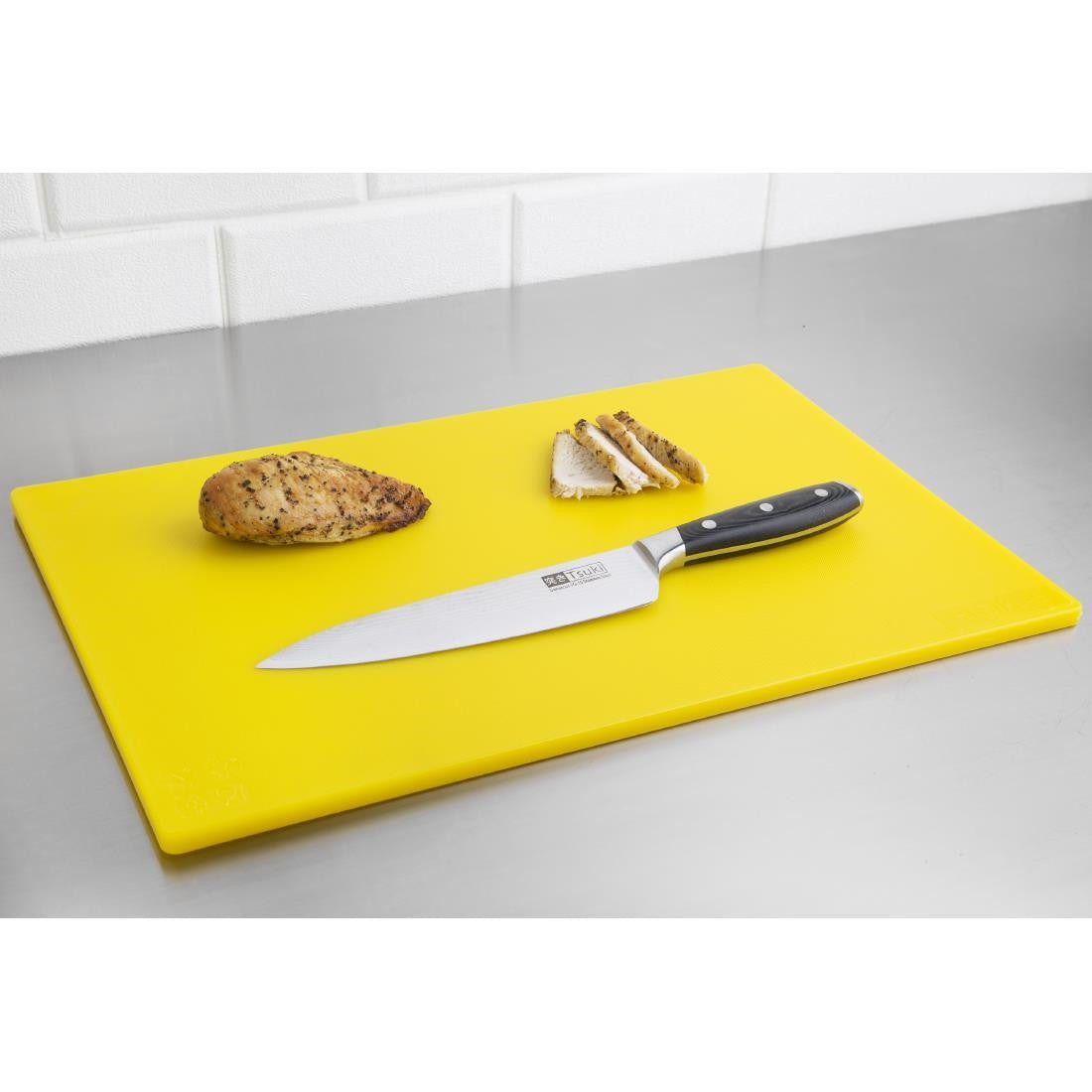 Hygiplas Low Density Yellow Chopping Board Standard with bread and knife on top.