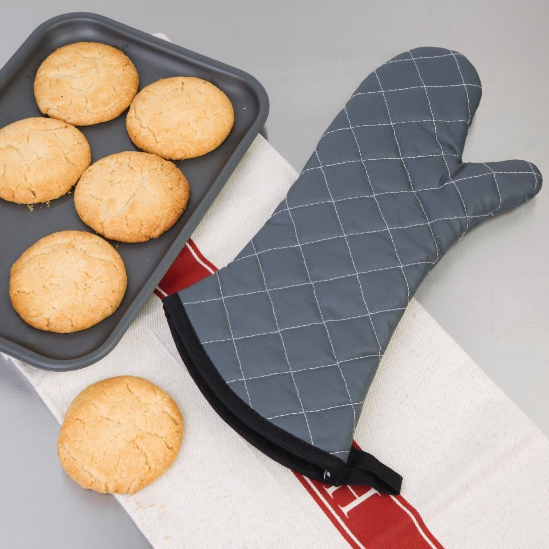 Vogue Flame Retardant Charcoal Oven Mitt 17" beside tray of cookies.